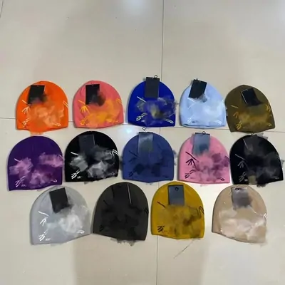 Tie-dye beanies in many colours laid out on a white surface with hang tags