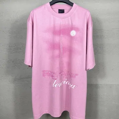 A pink oversized t-shirt with a faded graphic print displayed on a mannequin torso